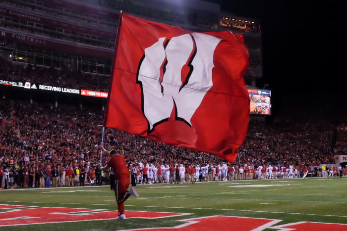 Wisconsin flag bearer runs across the field.