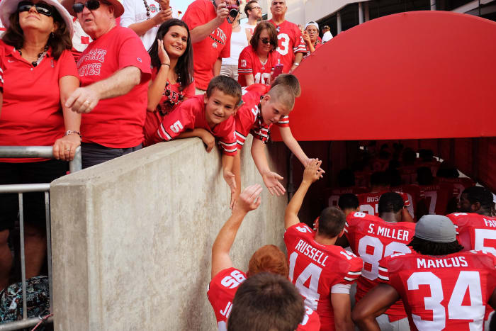 Ohio State players interacting with fans as they leave the field.
