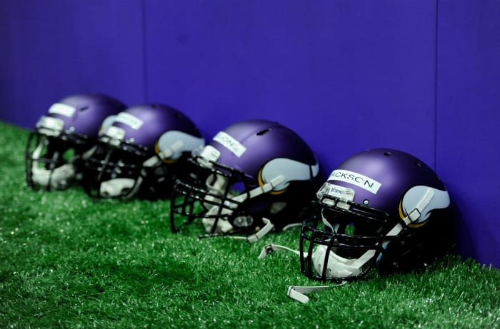 Four Minnesota Vikings helmets sitting on the field.