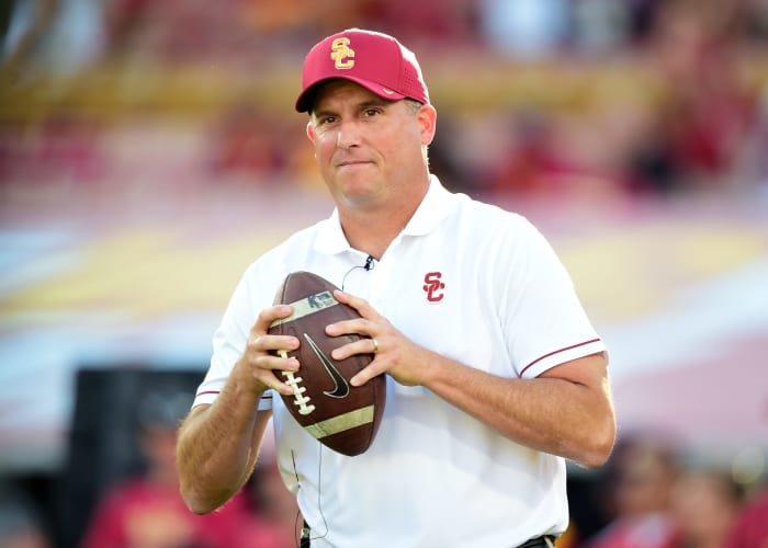 Clay Helton holding a football.