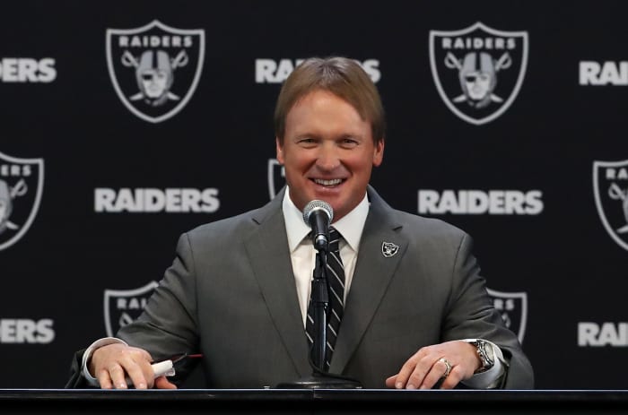 Jon Gruden speaking at a podium.