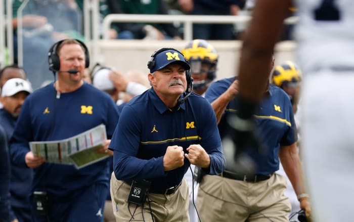 Michigan football defensive coordinator Don Brown flexes.