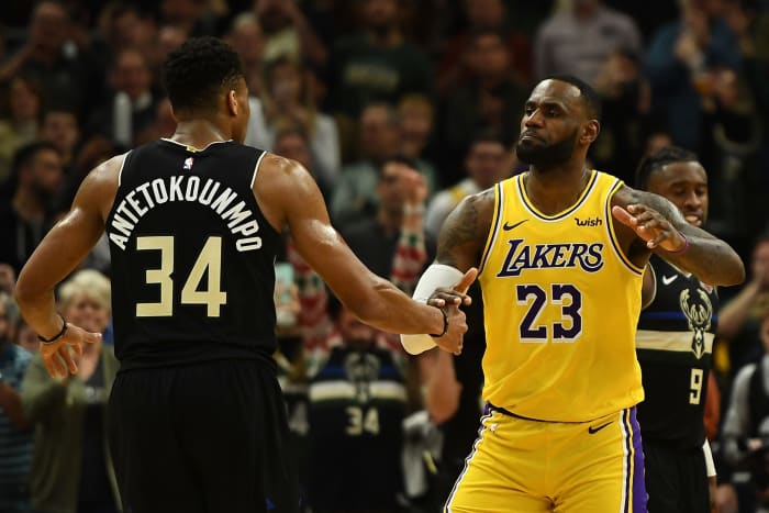 NBA stars LeBron James of the Los Angeles Lakers and Giannis Antetokounmpo of the Milwaukee Bucks hug after a game.