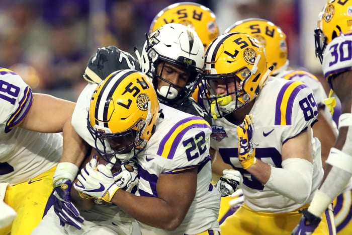 A UCF player tackling an LSU back Clyde Edwards-Helaire.