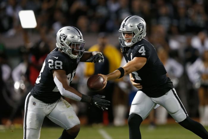 Derek Carr hands the ball off to Josh Jacobs of the Oakland Raiders.