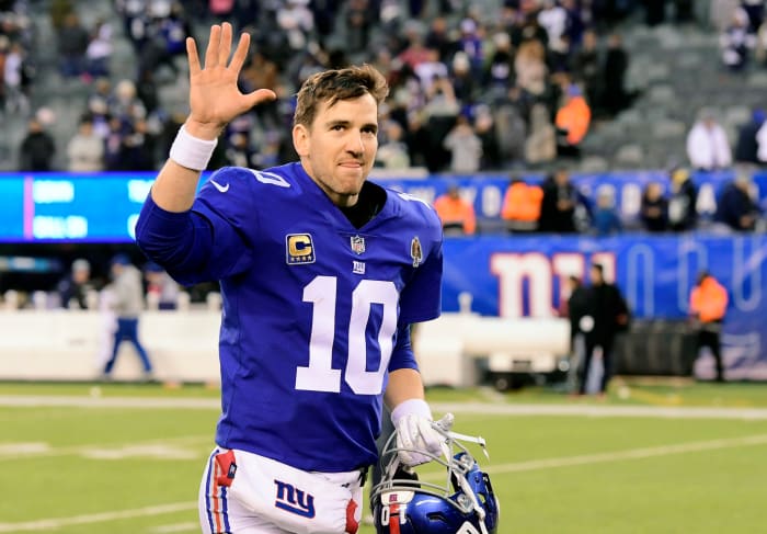 New York Giants QB Eli Manning waving as he walks off the field.