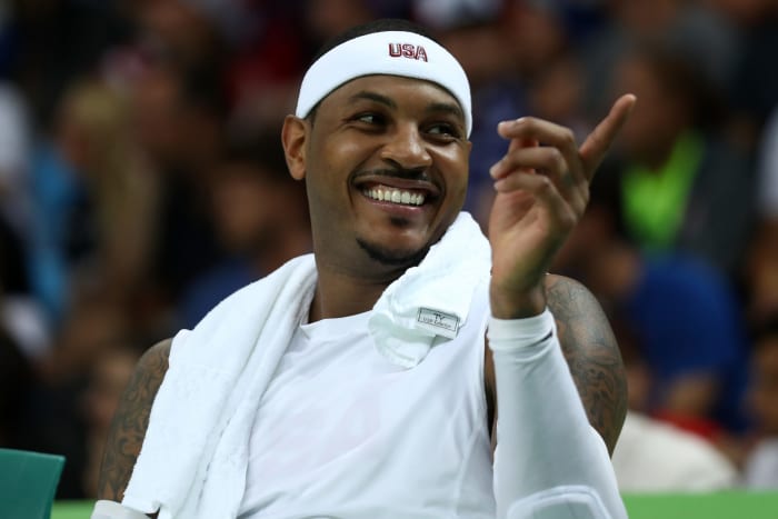 Carmelo Anthony smiling while on the bench for Team USA.
