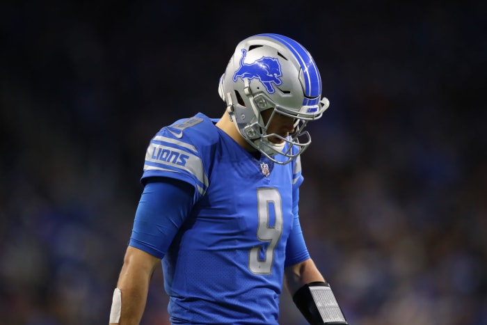 Detroit Lions QB Matthew Stafford walking off the field with his head down.