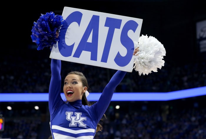A Kentucky cheerleader holding up a sign that says Cats.