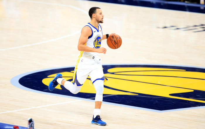 Stephen Curry dribbling the ball up the court.