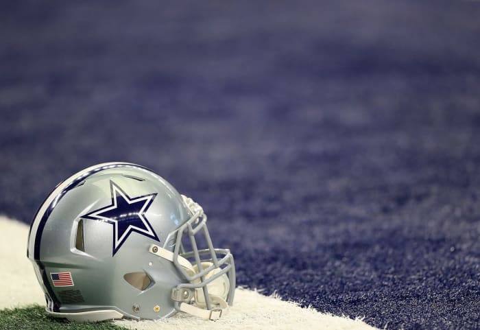 A Dallas Cowboys helmet sitting on the field.