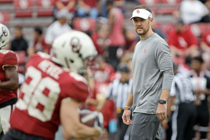 Lincoln Riley watching his players warm up before an Oklahoma football game.