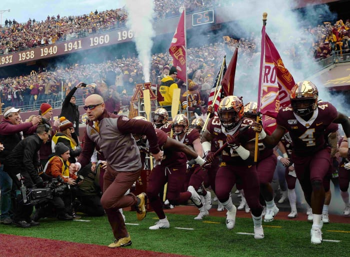 P.J. Fleck leads Minnesota onto the field ahead of a game with Penn State during the 2019 season.