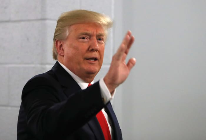 President Donald Trump waving before the College Football Playoff. He is currently pushing for Big Ten football to restart.