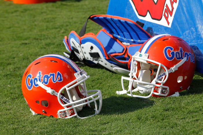 Two Florida Gators helmets sitting on the field.