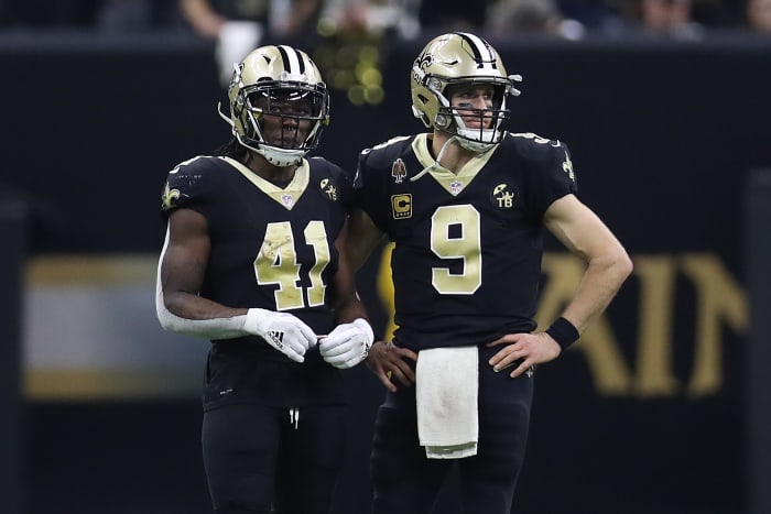 Alvin Kamara standing next to Drew Brees during a Saints game.