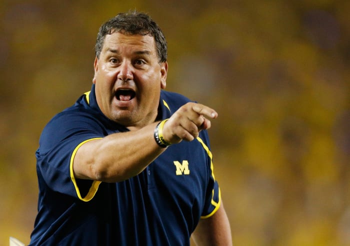 A closeup of Brady Hoke pointing while wearing a Michigan polo.