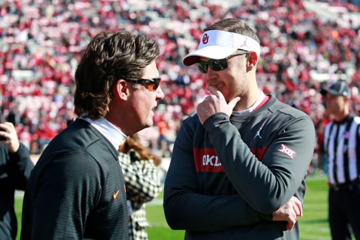 Mike Gundy and Lincoln Riley speak on the field before a game.
