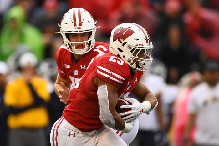 Wisconsin quarterback Jack Coan hands the football off to Jonathan Taylor.