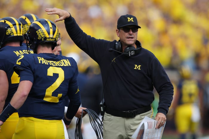 Michigan football head coach Jim Harbaugh patting quarterback Shea Patterson on the head.