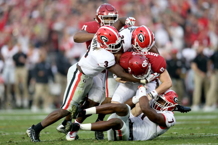 Georgia players make gang tackle on Oklahoma QB Baker Mayfield.