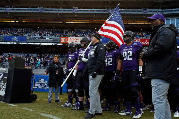 Northwestern college football coach Pat Fitzgerald leading his team onto the Pinstripe Bowl field.