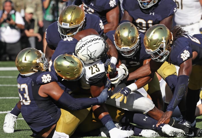 Drue Tranquill, Daelin Hayes and other Notre Dame football defenders make a gang tackle against Vanderbilt.