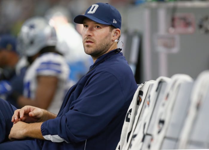 tony romo sits on the sideline during a game against the redskins