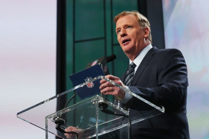 Roger Goodell talking at a podium at the NFL draft.