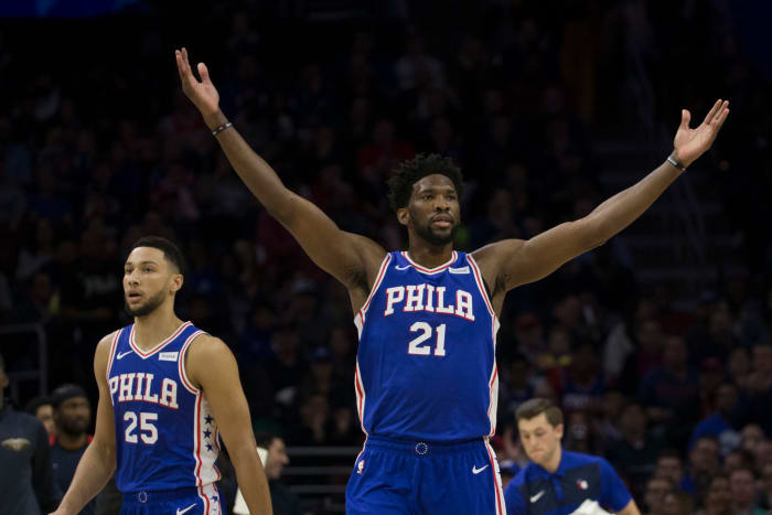 Joel Embiid raising his arms during a Philadelphia 76ers game. He reportedly approves of Mike D'Antoni as potential next Sixers coach.