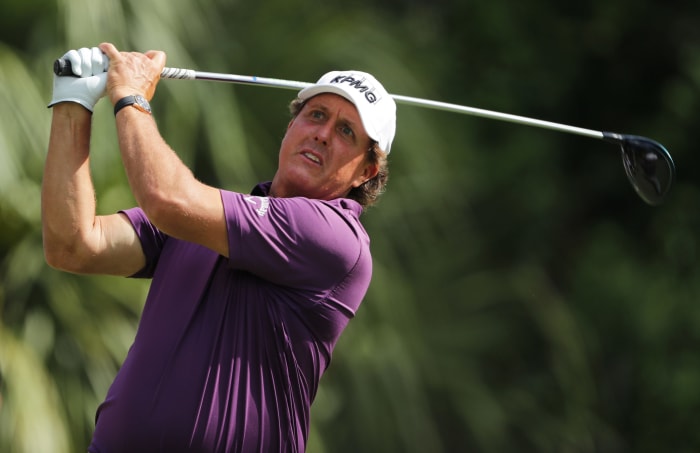 Phil Mickelson looking at his shot as it flies through the air.