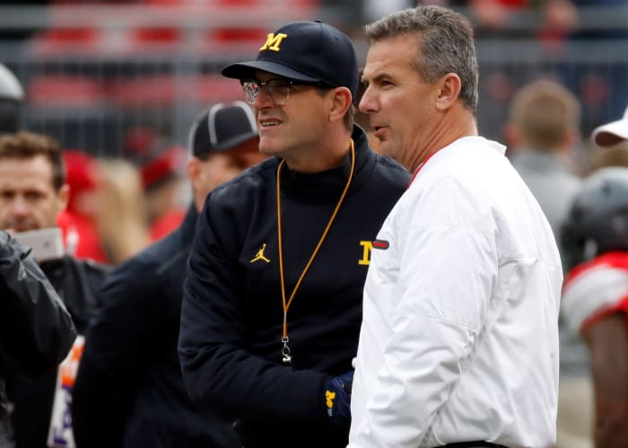 Head coach Urban Meyer of the Ohio State Buckeyes and Head coach Jim Harbaugh of the Michigan Wolverines talk on the field prior to their game.