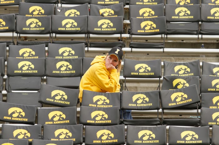 An Iowa fan sitting by herself before a football game.