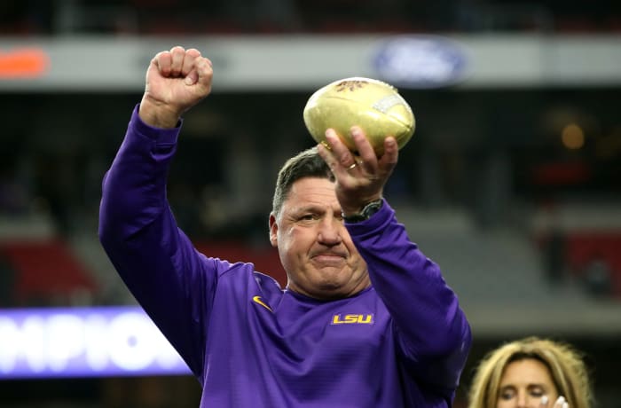 LSU football coach Ed Orgeron holding a trophy.