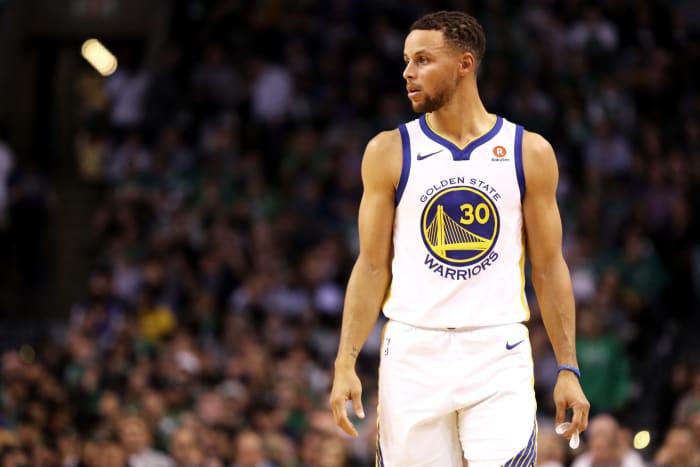 Steph Curry holding his mouthguard in his left hand.