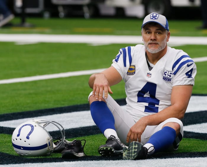 A grey bearded Adam Vinatieri sitting on the field.