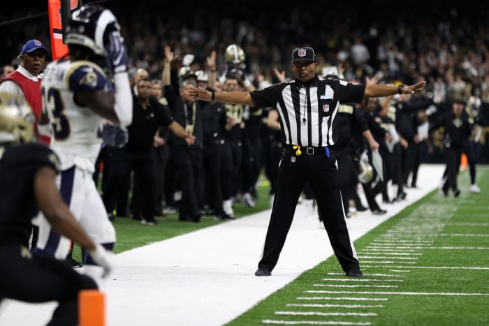 Referee signals incomplete pass during a game.