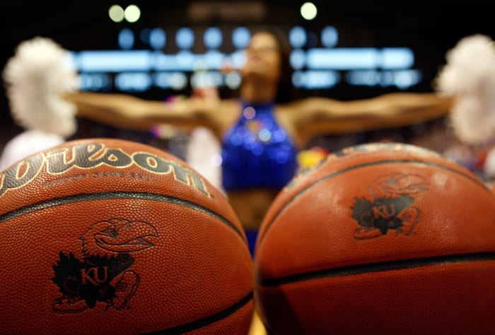 LAWRENCE, KS - FEBRUARY 07: A cheerleader cheers behind balls displaying the Kansas logo prior to the start of the game between the Oklahoma State Cowboys and the Kansas Jayhawks on February 7, 2009 at Allen Fieldhouse in Lawrence, Kansas. (Photo by Jamie Squire/Getty Images)