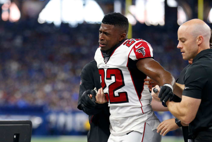 Keanu Neal exits the field in pain after being injured.