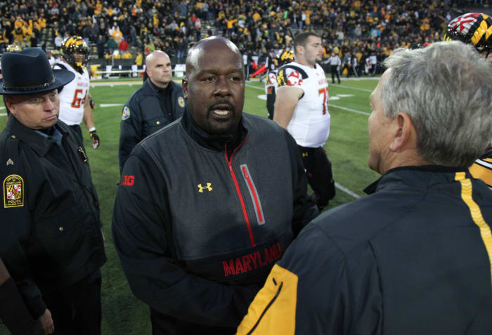 Mike Locksley greets Kirk Ferentz at midfield.