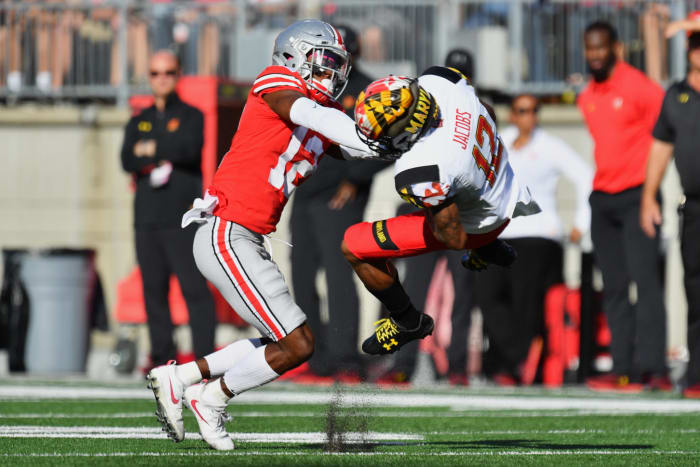 Denzel Ward tackling a Maryland player during a college football game.