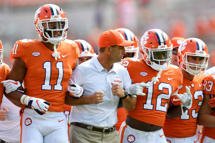 Dabo Swinney locking arms with his Clemson players.