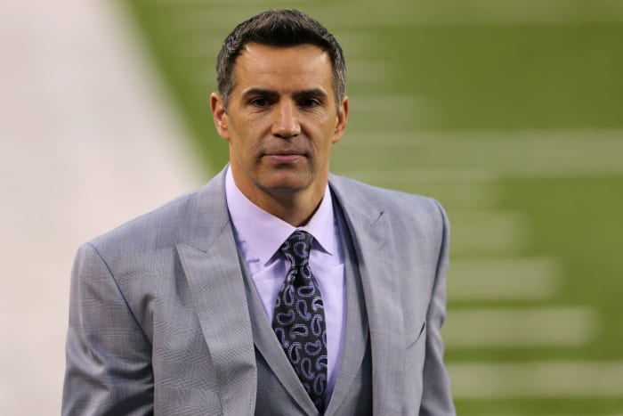 Kurt Warner wearing a suit on the sideline.