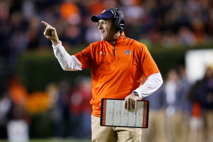 Gus Malzahn smiles and points while coaching Auburn.