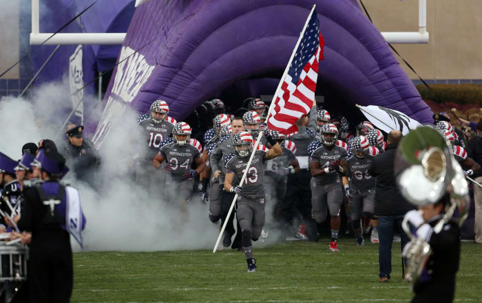 Northwestern coach Pat Fitzgerald leading his team onto the field.