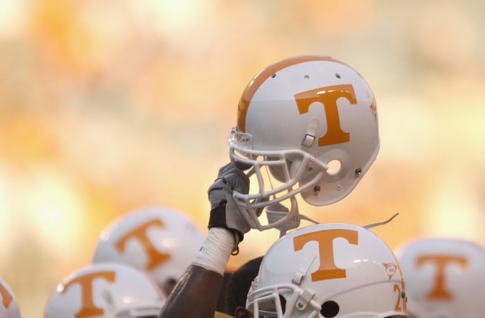 A Tennessee football player holding up his helmet before a game.