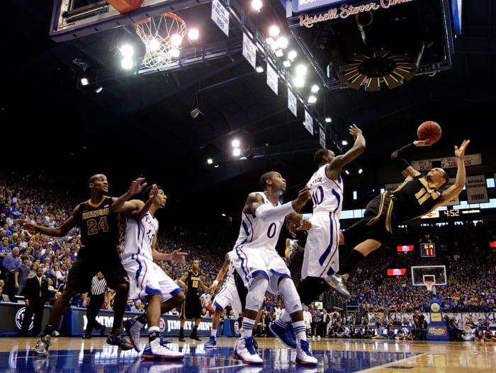 Kansas and Missouri players battle under the basket during a game.