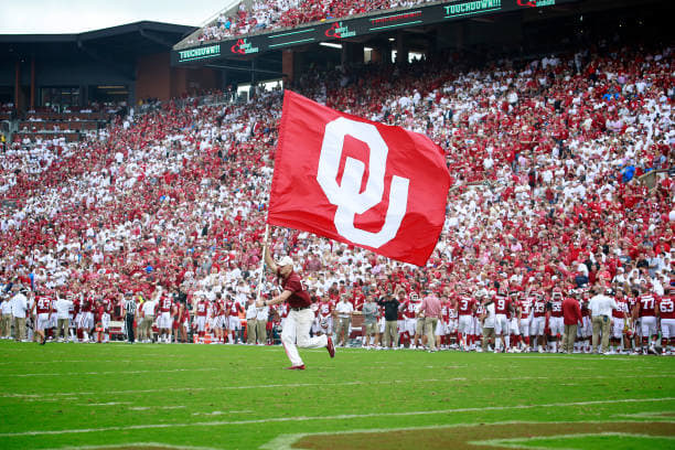 Oklahoma flag is run on field ahead of home game.