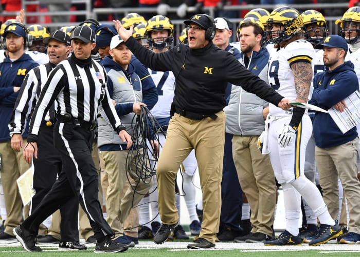 Jim Harbaugh of the Michigan Wolverines argues a call on the sideline.