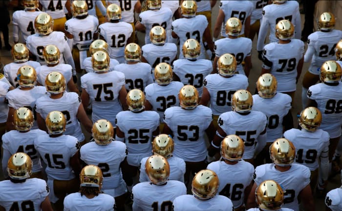 Notre Dame football players walking onto the field.